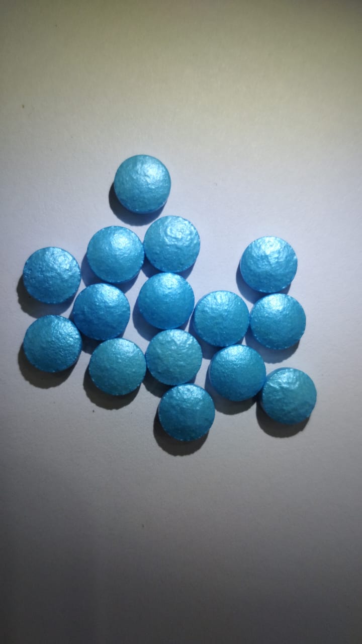 Metallic blue round coated tablets