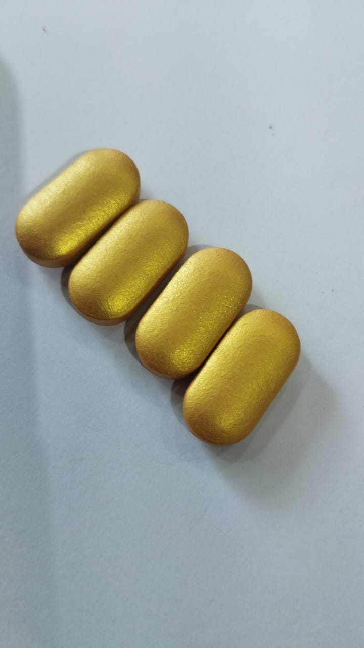 Close view of metallic gold coated caplets